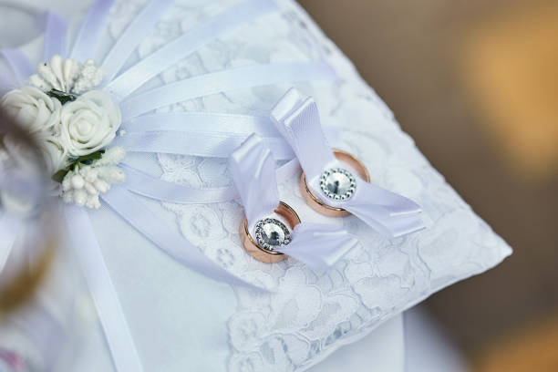istock Two Golden Wedding Rings  on a small satin pillows 1211990754