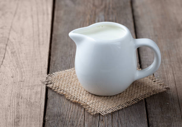 istock White jug with milk on a wooden rustic background 1211991177
