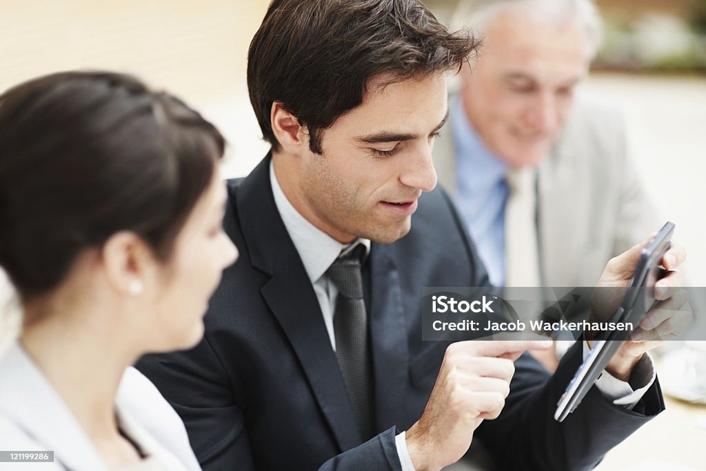 Un hombre de negocios haciendo cálculos durante una reunión - Foto de stock de Adulto libre de derechos