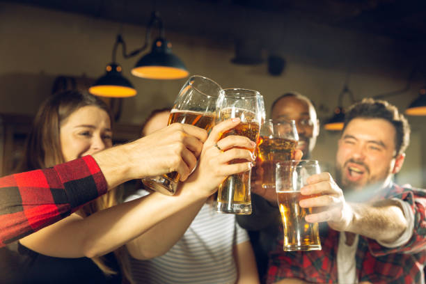 istock Sport fans cheering at bar, pub and drinking beer while championship, competition is going 1211992915