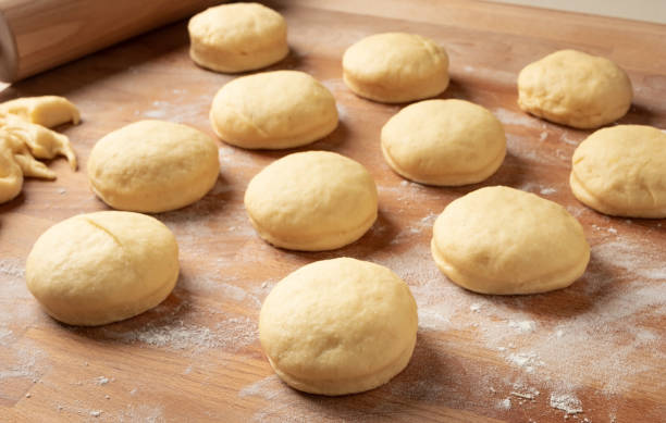 istock Homemade doughnuts filled with marmalade rising on a rolling board 1211993072