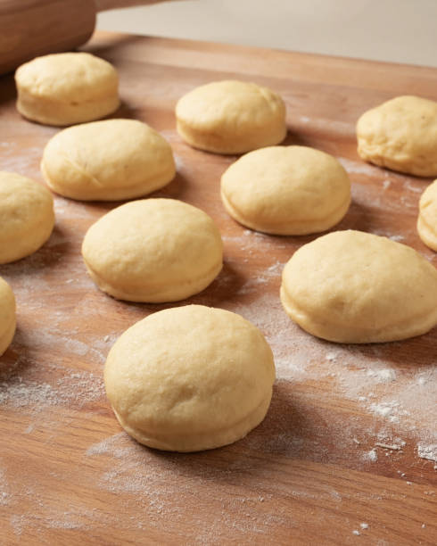 istock Homemade doughnuts filled with marmalade rising on a rolling board 1211993091