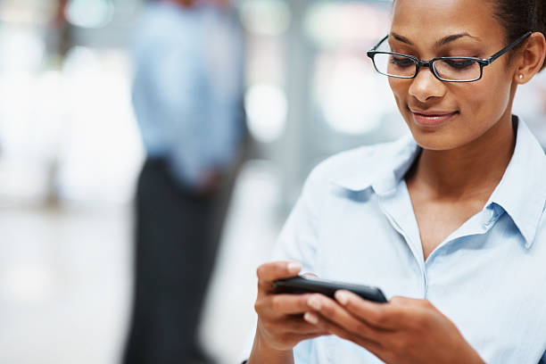 istock Black business woman text messaging on cell phone 121199497