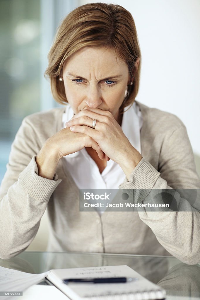 Disappointed mature businessswoman thinking about something Portrait of disappointed mature businesswoman thinking over something One Woman Only Stock Photo