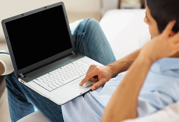 primo piano di uomo che lavora su un computer portatile indoor - track pad foto e immagini stock