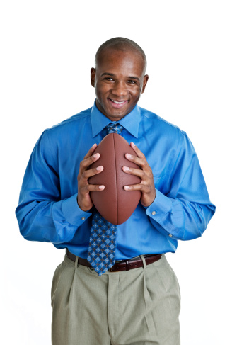 Man in suit holding a football shot on white background