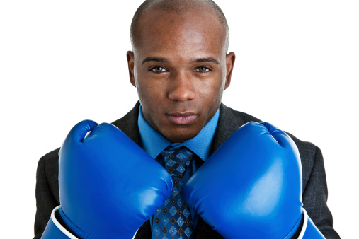 African American man wearing a suit and boxing gloves shot on white background