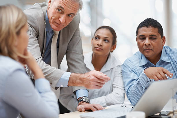 istock Senior business man discussing project on laptop with staff 121200460