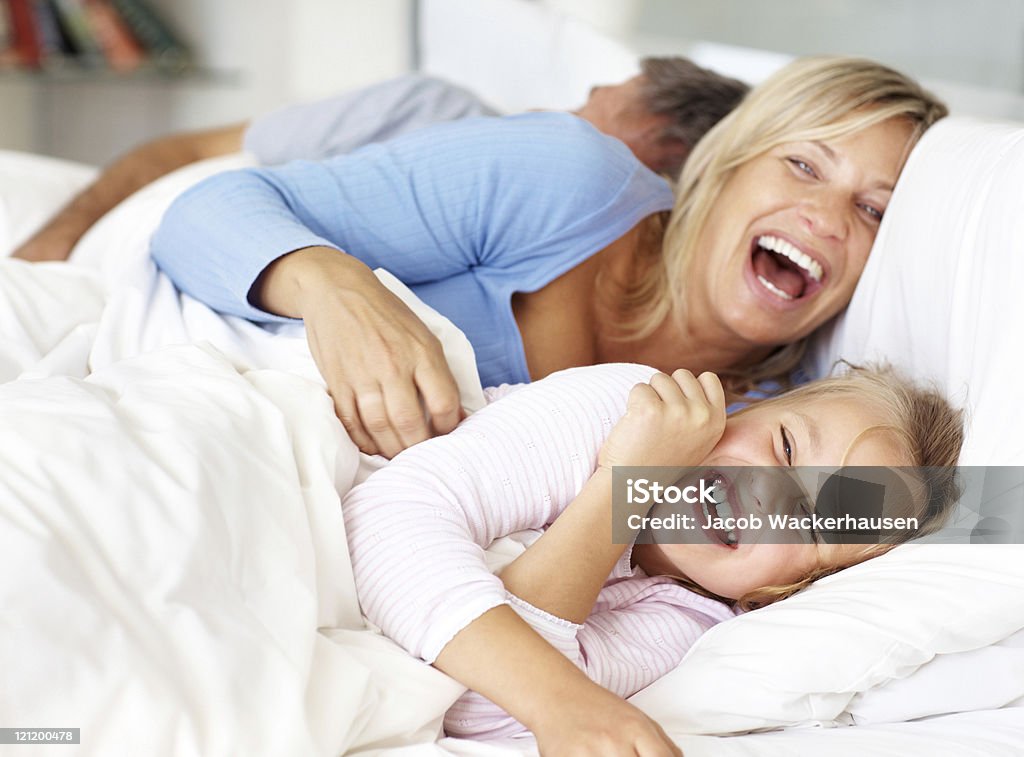 Happy family having fun in morning on bed Portrait of happy family having fun in morning on the bed at home Bed - Furniture Stock Photo