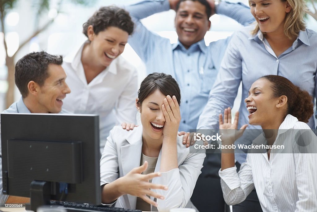 Colleagues enjoying  laugh on a funny email  Hand On Shoulder Stock Photo