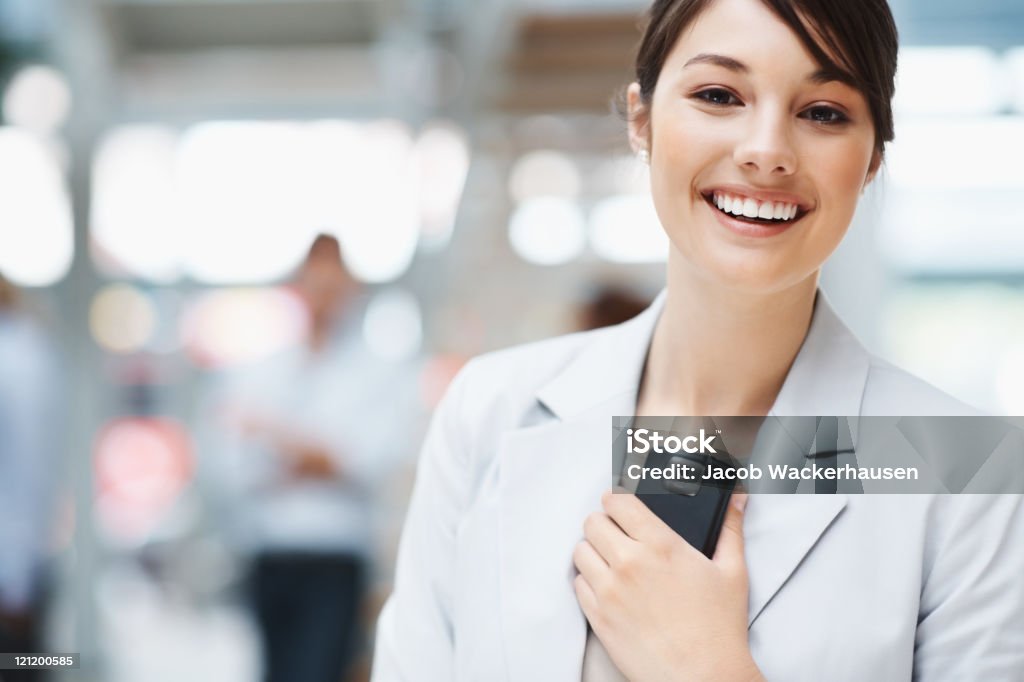 Süßes Lächeln business Frau hält ein Mobiltelefon - Lizenzfrei Attraktive Frau Stock-Foto