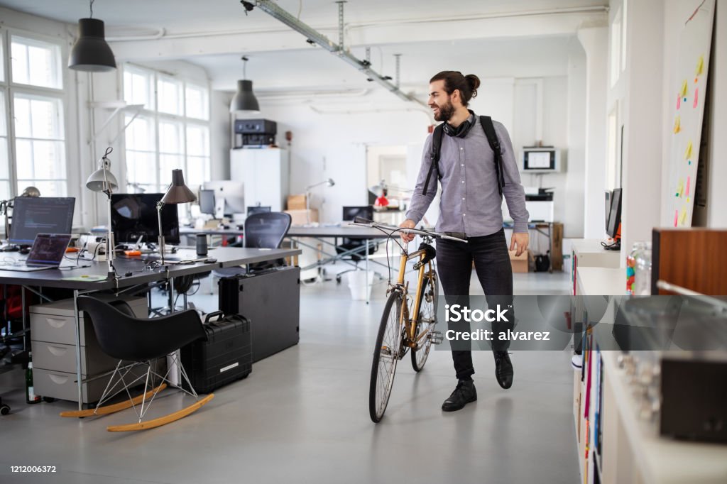 Businessman with a bicycle in office Businessman with a bicycle in office. Business professional going home after work. Office Stock Photo
