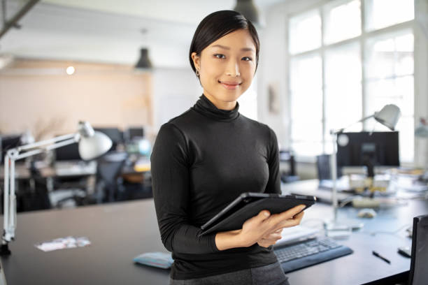 Confident asian businesswoman in office Portrait of young businesswoman standing in office with a digital tablet. Confident asian businesswoman in office. short hair photos stock pictures, royalty-free photos & images