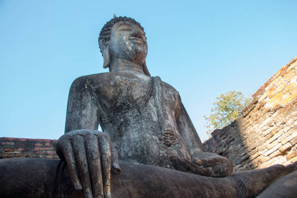 istock Big buddha statue is sitting an open roof building 1212007360