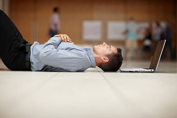 istock Tired young man lying on floor with a laptop 121200845