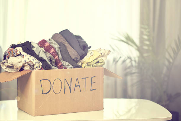 istock Donation box with clothing on the table. garage sale, second hand 1212008651