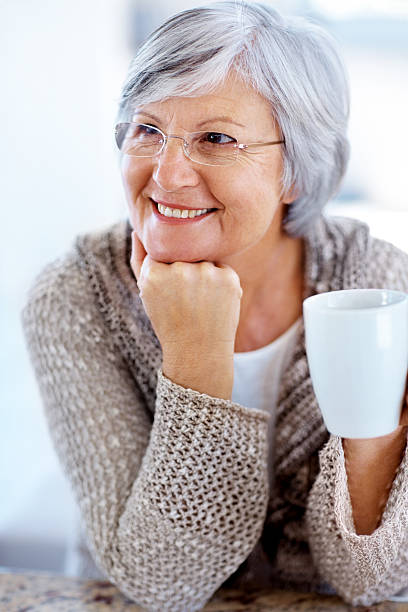 senior donna guardando qualcosa di interessante con caffè - 4694 foto e immagini stock