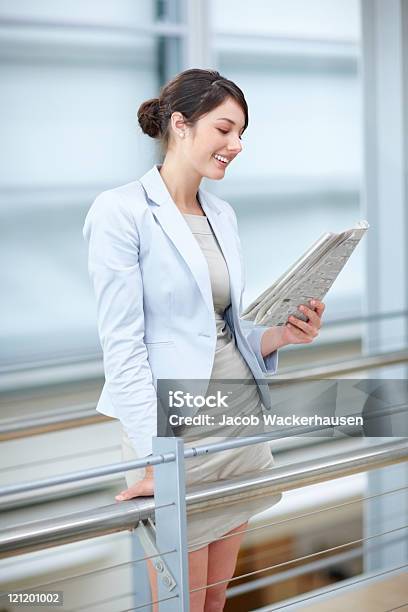 笑顔のビジネス女性の読書新聞手すり - オフィスのストックフォトや画像を多数ご用意 - オフィス, ビジネスパーソン, 手に持つ