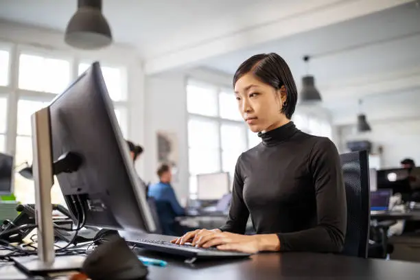 Photo of Woman busy working at her desk in open plan office