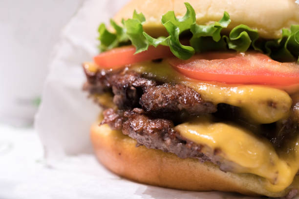 doppio cheeseburger con lattuga di pomodoro e cipolla, patatine fritte al formaggio e frullato. - shakerismo foto e immagini stock