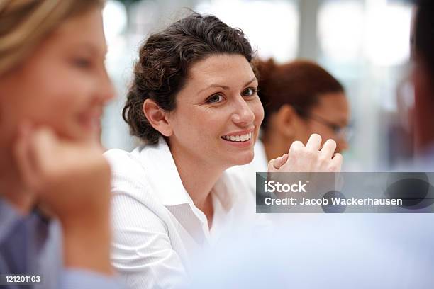 Smiling Woman Sitting At A Business Meeting With Colleagues Stock Photo - Download Image Now