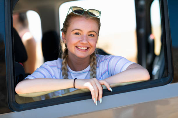 istock Woman with blond braids smiling at camera from car 1212013682