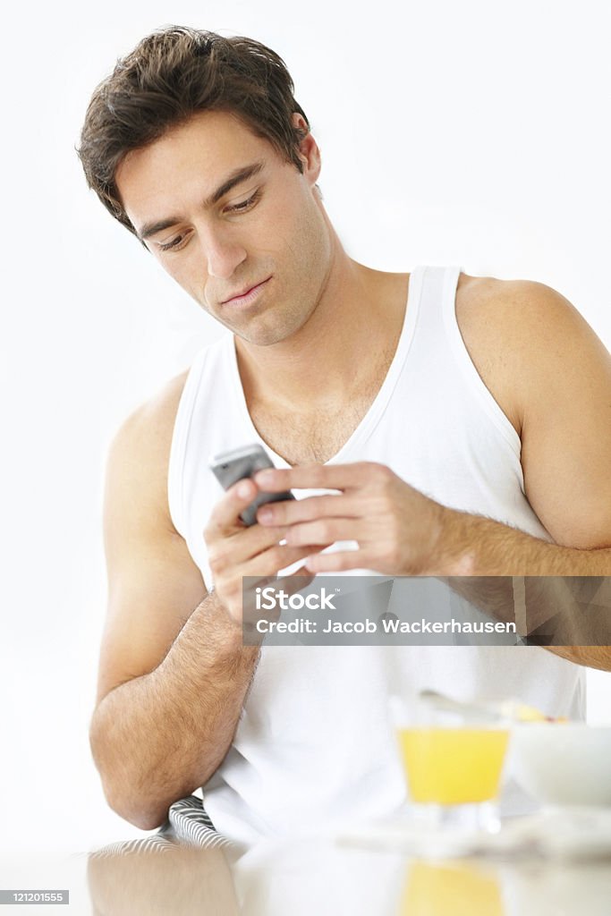 Beau jeune mec SMS sur téléphone portable - Photo de 20-24 ans libre de droits