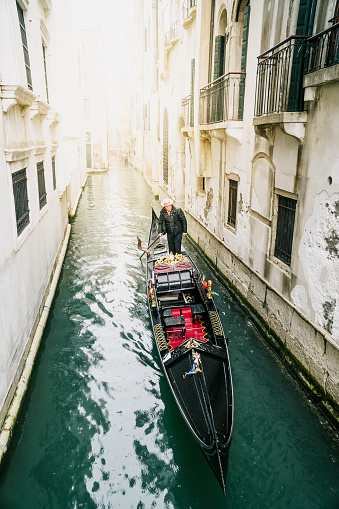 Venice, Italy. March 2, 2020. One gondola sailing in the Venice canal. Gondola on Canal Grande, Venice, Italy