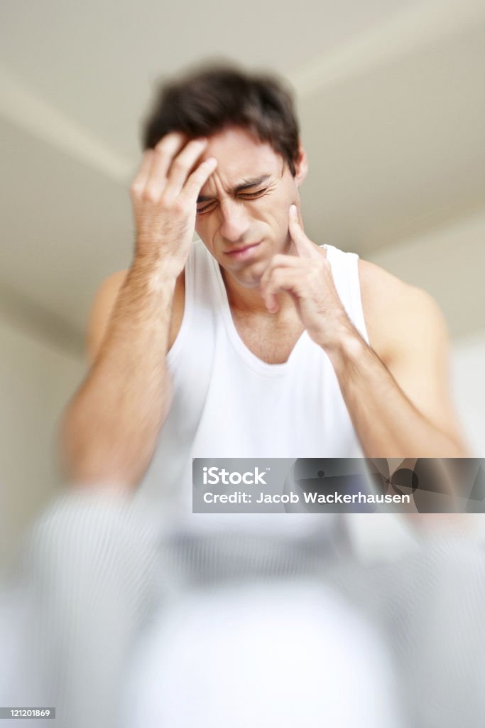 Migraine - Young man suffering from headache  Adult Stock Photo