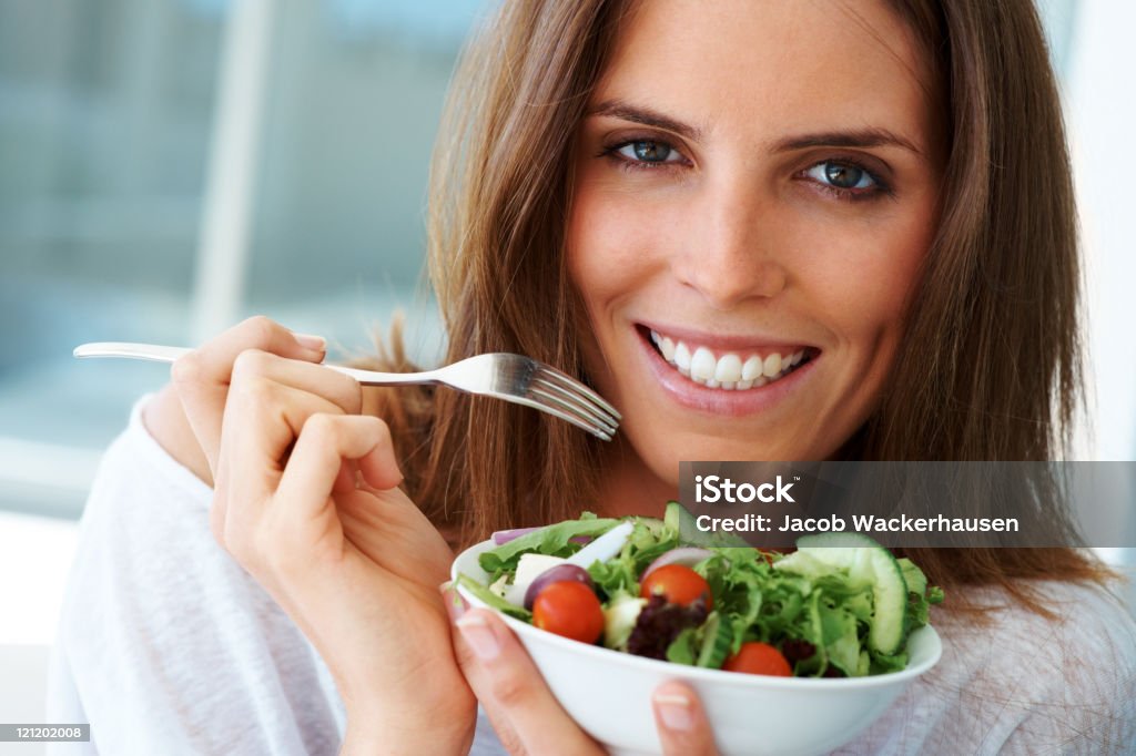 Close-up of happy woman eating vegetable salad  Women Stock Photo