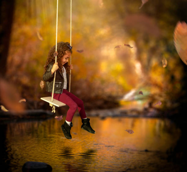 Little girl swinging over pond