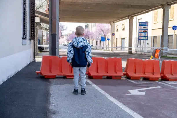 Photo of Little boy standing on the closed border between Italy and Slovenia