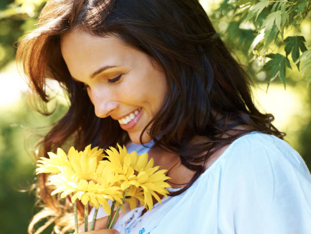 bella mujer joven con flores amarillas en el parque - sunflower side view yellow flower fotografías e imágenes de stock