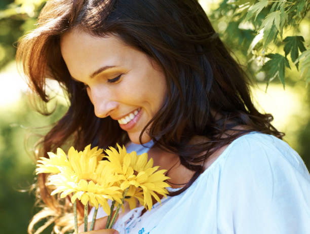 bela jovem com flores amarelas em um parque - sunflower side view yellow flower imagens e fotografias de stock