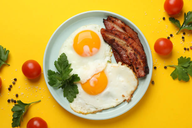 istock Delicious breakfast or lunch with fried eggs on yellow background, top view 1212022338
