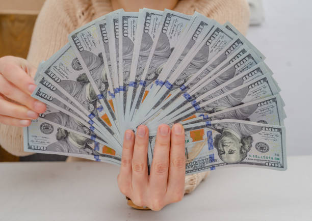 istock Hand holds american dollars spread out fan 1212028148
