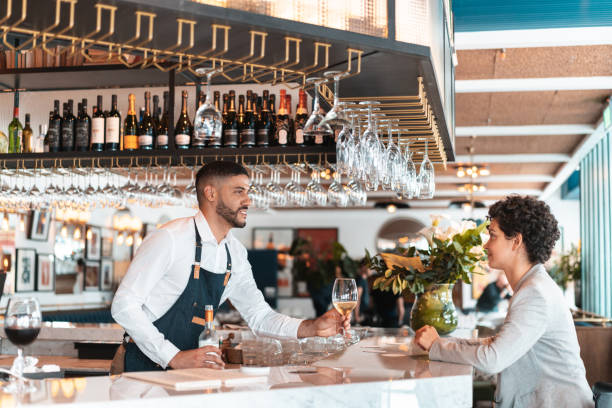 istock Woman at bar counter drinking white wine 1212029517
