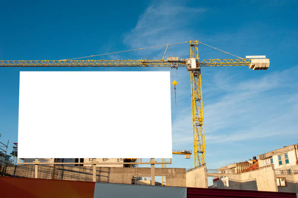 istock Blank billboard for advertisement on the construction site with cranes on a sunny day. 1212029571