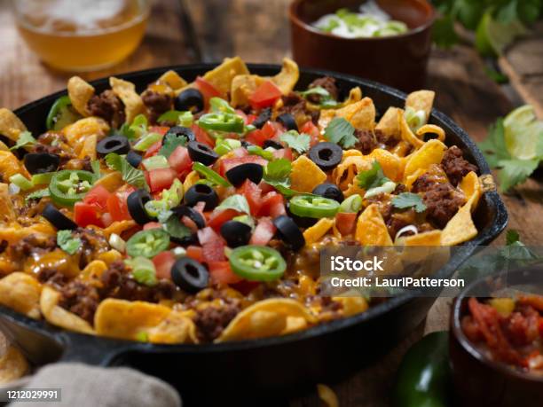 Baked Frito Pie With Black Olives Tomatoes Green Onions Jalapenos Salsa Guacamole And Sour Cream Stock Photo - Download Image Now