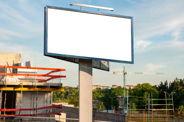 istock Blank billboard for advertisement on the construction site with cranes on a sunny day. 1212030026