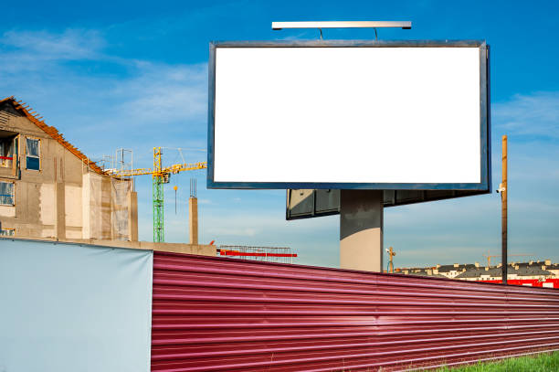 istock Blank billboard for advertisement on the construction site with cranes on a sunny day. 1212030826