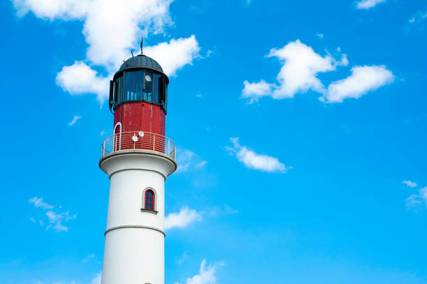 istock White lighthouse against blue sky on a summer day 1212030835