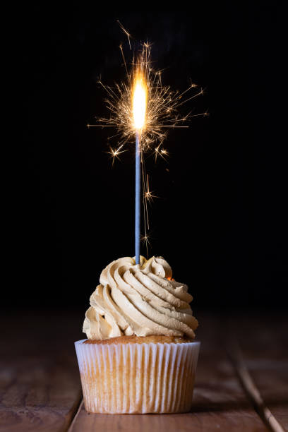 istock One cupcakes on a table with a sparkle and a black background 1212032880