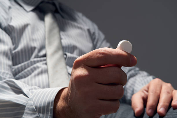 istock businessman with a pill, hands close view - concept of difficulties, depression, problems, health and stress, risk of modern business 1212033751