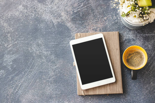 istock Digital tablet, notebook and coffee on office desk 1212033789