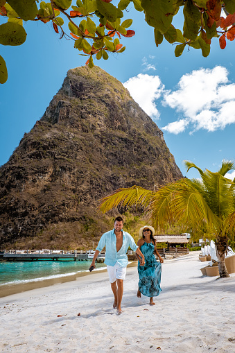 Saint Lucia Caribbean Island, couple on luxury vatation at the tropical Island of Saint Lucia, men and woman by the beach and crystal clear ocean of St Lucia Caribbean Holliday during sunset with white beach and palm trees