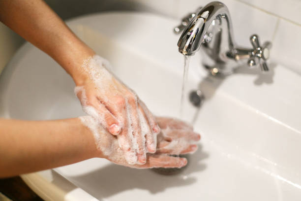 istock Washing hands. Hands washing with proper technique and antibacterial soap on background of flowing water in bathroom. Rubbing fingers. Prevent coronavirus epidemic. Prevention of flu disease. 1212034746