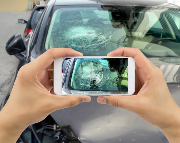 человек фотографирование его автомобиль с повреждениями в городе - shattered glass broken window damaged стоковые фото и изображения