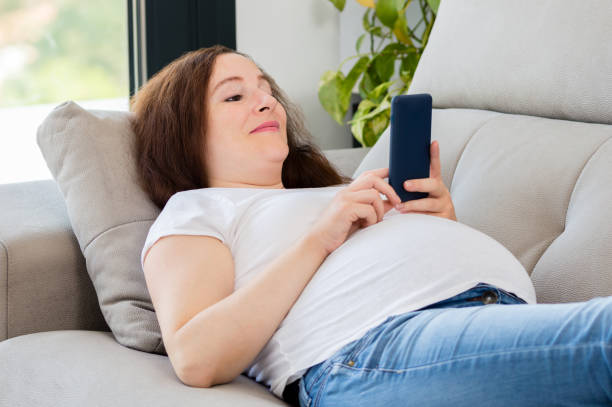 istock Comfortable woman at home texting on a mobile phone 1212036141