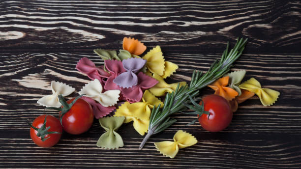 massa italiana seca farfalle ou arcos com tomates e alecrim - bow tie pasta italian cuisine bow heap - fotografias e filmes do acervo